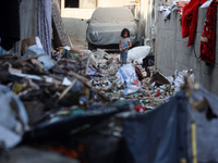 Palestinians are inspecting a house destroyed in an Israeli strike, amid the Israel-Hamas conflict, in Nusairat refugee camp, in the central...