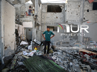 Palestinians are inspecting a house destroyed in an Israeli strike, amid the Israel-Hamas conflict, in Nusairat refugee camp, in the central...