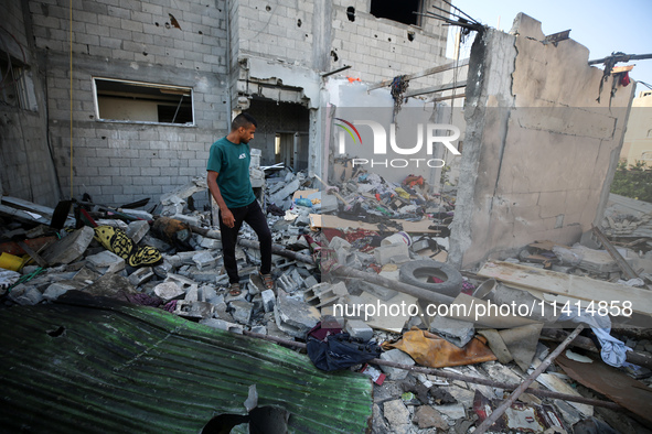 Palestinians are inspecting a house destroyed in an Israeli strike, amid the Israel-Hamas conflict, in Nusairat refugee camp, in the central...