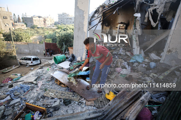 Palestinians are inspecting a house destroyed in an Israeli strike, amid the Israel-Hamas conflict, in Nusairat refugee camp, in the central...