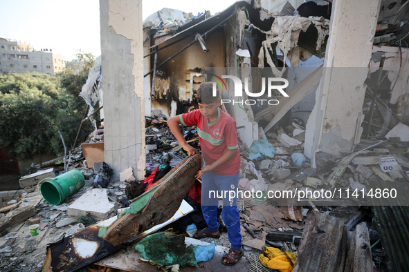 Palestinians are inspecting a house destroyed in an Israeli strike, amid the Israel-Hamas conflict, in Nusairat refugee camp, in the central...