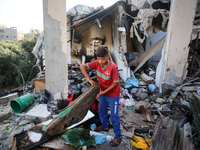 Palestinians are inspecting a house destroyed in an Israeli strike, amid the Israel-Hamas conflict, in Nusairat refugee camp, in the central...