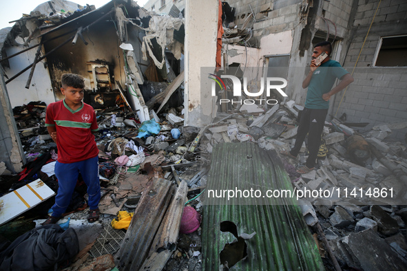 Palestinians are inspecting a house destroyed in an Israeli strike, amid the Israel-Hamas conflict, in Nusairat refugee camp, in the central...