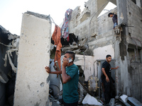 Palestinians are inspecting a house destroyed in an Israeli strike, amid the Israel-Hamas conflict, in Nusairat refugee camp, in the central...