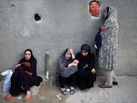 Palestinian women are reacting at the site of an Israeli strike on a house, in Nuseirat, central Gaza Strip, on July 17, 2024, amid the ongo...