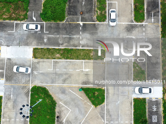 A trainee is practicing driving on the training ground of Jindun Driver Training School in Chaohu City, Anhui province, China, on July 17, 2...