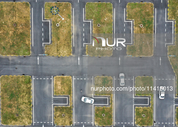 A trainee is practicing driving on the training ground of Jindun Driver Training School in Chaohu City, Anhui province, China, on July 17, 2...