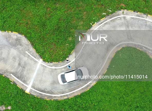 A trainee is practicing driving on the training ground of Jindun Driver Training School in Chaohu City, Anhui province, China, on July 17, 2...