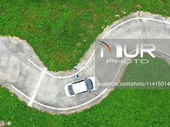 A trainee is practicing driving on the training ground of Jindun Driver Training School in Chaohu City, Anhui province, China, on July 17, 2...