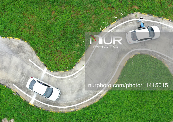 A trainee is practicing driving on the training ground of Jindun Driver Training School in Chaohu City, Anhui province, China, on July 17, 2...