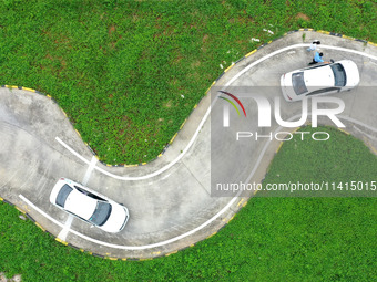 A trainee is practicing driving on the training ground of Jindun Driver Training School in Chaohu City, Anhui province, China, on July 17, 2...