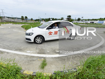 A trainee is practicing driving on the training ground of Jindun Driver Training School in Chaohu City, Anhui province, China, on July 17, 2...