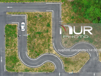 A trainee is practicing driving on the training ground of Jindun Driver Training School in Chaohu City, Anhui province, China, on July 17, 2...