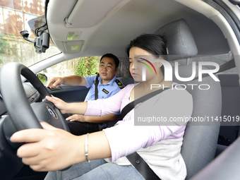 A trainee is practicing driving on the training ground of Jindun Driver Training School in Chaohu City, Anhui province, China, on July 17, 2...