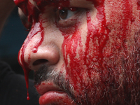 Blood is dripping from the nose of a Shi'ite Muslim man after flagellating himself during a Muharram procession marking Ashura, in Kolkata,...