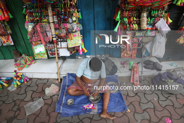 A vendor is making toys for selling during a Muharram procession marking Ashura in Kolkata, India, on July 17, 2024. 