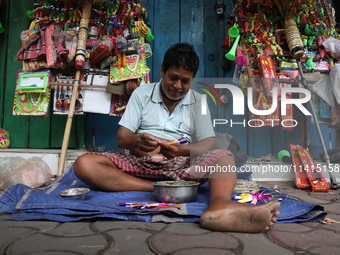 A vendor is making toys for selling during a Muharram procession marking Ashura in Kolkata, India, on July 17, 2024. (