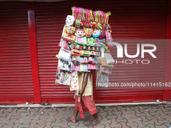 A vendor is walking after arranging toys for selling during a Muharram procession marking Ashura, in Kolkata, India, on July 17, 2024. (