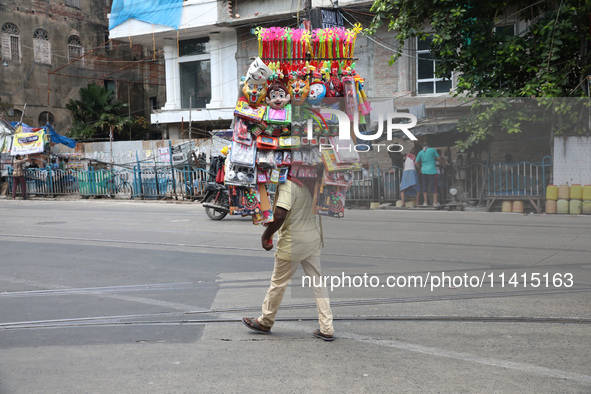 A vendor is walking after arranging toys for selling during a Muharram procession marking Ashura, in Kolkata, India, on July 17, 2024. 