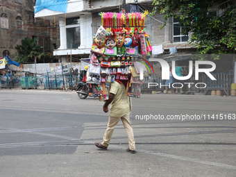 A vendor is walking after arranging toys for selling during a Muharram procession marking Ashura, in Kolkata, India, on July 17, 2024. (