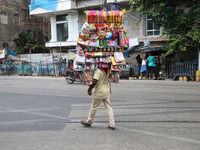 A vendor is walking after arranging toys for selling during a Muharram procession marking Ashura, in Kolkata, India, on July 17, 2024. (