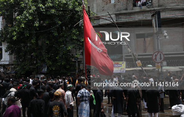 A Shi'ite Muslim is holding a religious flag during a Muharram procession marking Ashura, in Kolkata, India, on July 17, 2024. 