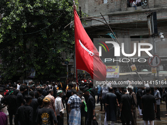 A Shi'ite Muslim is holding a religious flag during a Muharram procession marking Ashura, in Kolkata, India, on July 17, 2024. (