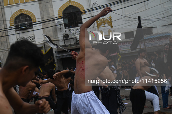 Shiite Muslims are flagellating themselves during a procession to mark Ashura, in the old quarters of New Delhi, India, on July 17, 2024. As...