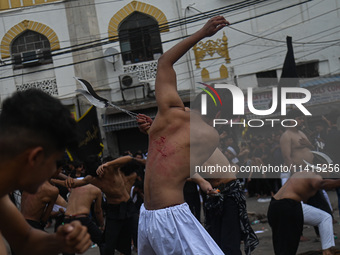 Shiite Muslims are flagellating themselves during a procession to mark Ashura, in the old quarters of New Delhi, India, on July 17, 2024. As...