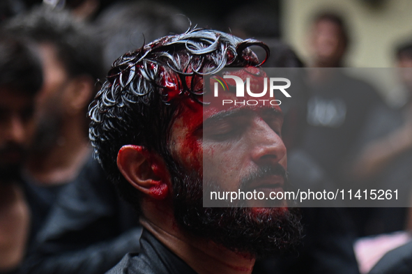 A Shiite Muslim man is being seen with blood on his face during a procession to mark Ashura, in the old quarters of New Delhi, India, on Jul...