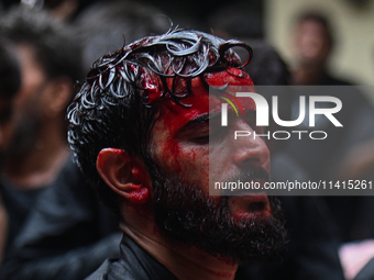 A Shiite Muslim man is being seen with blood on his face during a procession to mark Ashura, in the old quarters of New Delhi, India, on Jul...