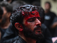 A Shiite Muslim man is being seen with blood on his face during a procession to mark Ashura, in the old quarters of New Delhi, India, on Jul...