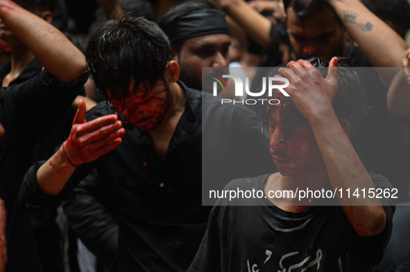 Shiite Muslims are hitting themselves on their heads as they bleed during a procession to mark Ashura, in the old quarters of New Delhi, Ind...