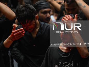 Shiite Muslims are hitting themselves on their heads as they bleed during a procession to mark Ashura, in the old quarters of New Delhi, Ind...