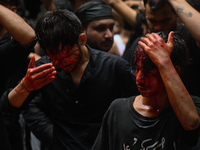 Shiite Muslims are hitting themselves on their heads as they bleed during a procession to mark Ashura, in the old quarters of New Delhi, Ind...