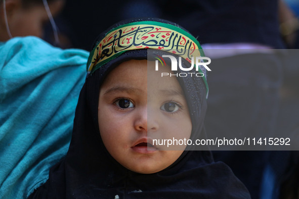 A Shiite Muslim girl is looking on during a religious procession on the tenth day of Ashura in the Islamic month of Muharram in Srinagar, Ja...