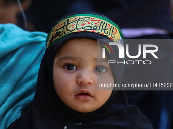 A Shiite Muslim girl is looking on during a religious procession on the tenth day of Ashura in the Islamic month of Muharram in Srinagar, Ja...