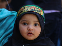 A Shiite Muslim girl is looking on during a religious procession on the tenth day of Ashura in the Islamic month of Muharram in Srinagar, Ja...