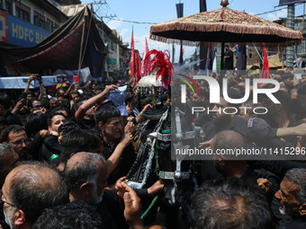 Kashmiri Shiite Muslims are reenacting the scene by touching the horse during a religious procession on the tenth day of Ashura in the Islam...