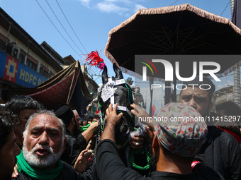 Kashmiri Shiite Muslims are reenacting the scene by touching the horse during a religious procession on the tenth day of Ashura in the Islam...