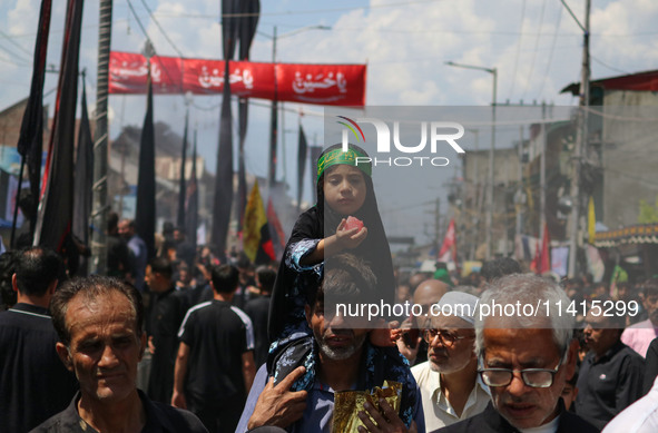 A Shiite Muslim girl is looking on during a religious procession on the tenth day of Ashura in the Islamic month of Muharram in Srinagar, Ja...