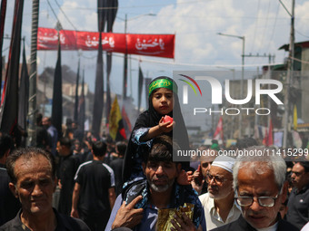 A Shiite Muslim girl is looking on during a religious procession on the tenth day of Ashura in the Islamic month of Muharram in Srinagar, Ja...