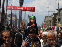 A Shiite Muslim girl is looking on during a religious procession on the tenth day of Ashura in the Islamic month of Muharram in Srinagar, Ja...