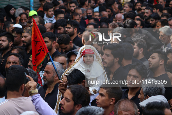 A Shiite Muslim girl is looking on during a religious procession on the tenth day of Ashura in the Islamic month of Muharram in Srinagar, Ja...