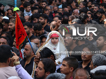 A Shiite Muslim girl is looking on during a religious procession on the tenth day of Ashura in the Islamic month of Muharram in Srinagar, Ja...