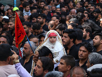 A Shiite Muslim girl is looking on during a religious procession on the tenth day of Ashura in the Islamic month of Muharram in Srinagar, Ja...