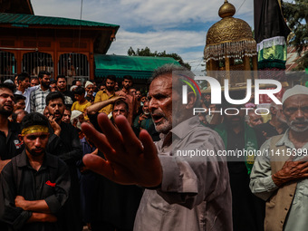 Kashmiri Shiite Muslims are chanting religious slogans as they take part in an Ashura procession during Muharram in Sopore, Jammu and Kashmi...