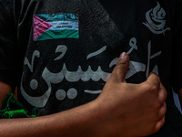 Shiite people are wearing Palestine flag stickers on their clothes while Muslims are chanting religious slogans as they take part in an Ashu...