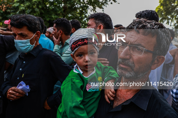 Shiite people are wearing Palestine flag stickers on their clothes while Muslims are chanting religious slogans as they take part in an Ashu...