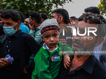 Shiite people are wearing Palestine flag stickers on their clothes while Muslims are chanting religious slogans as they take part in an Ashu...